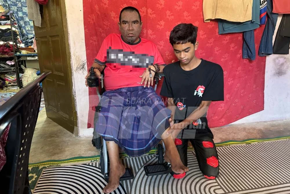 Mohd Zaharuddin (kiri) dibantu Shahrul Nizam untuk mengalihkan kakinya.